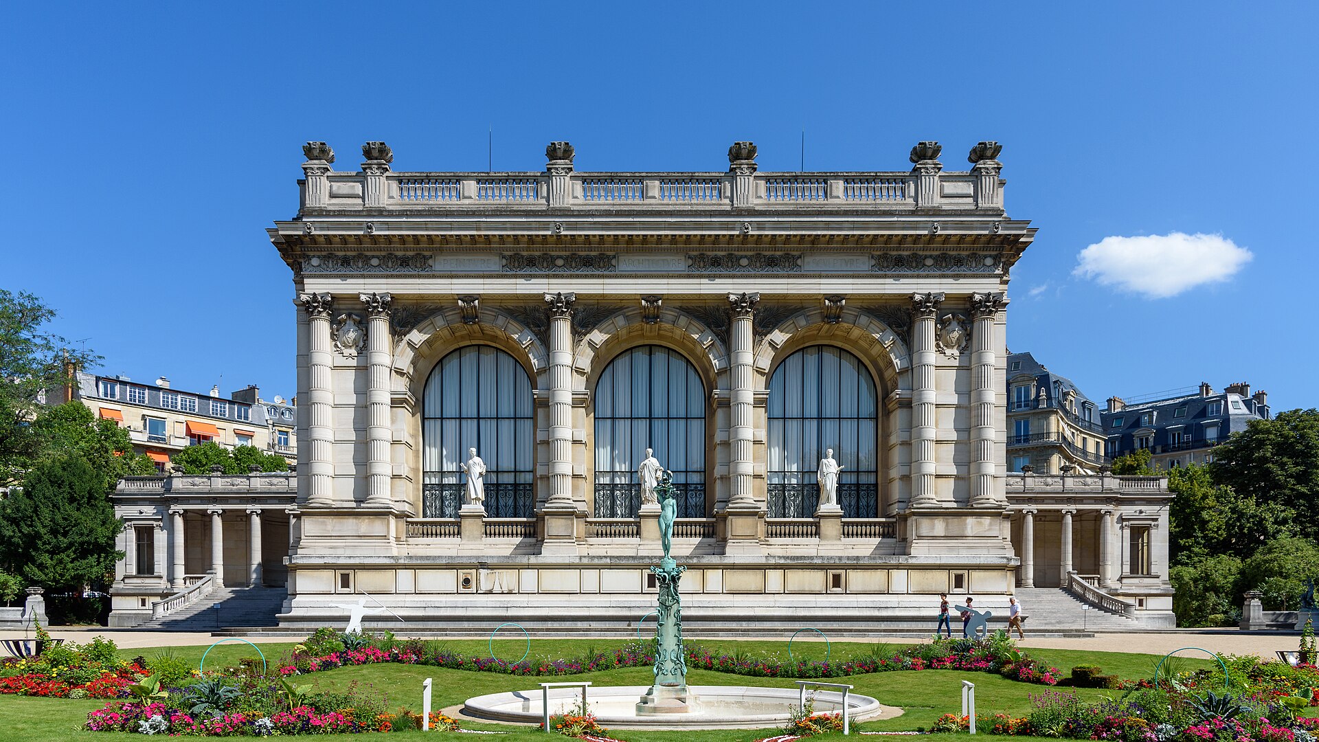 la facciata sud del palais galliera vista dal giardino, con tre grandi finestre ad arco, colonne corinzie accoppiate e tre statue bianche davanti alle vetrate