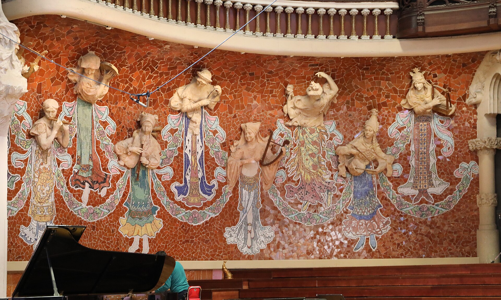 le muse del palau de la musica catalana sul fondo del palco, con il busto in rilievo bianco e le gonne a mosaico colorato