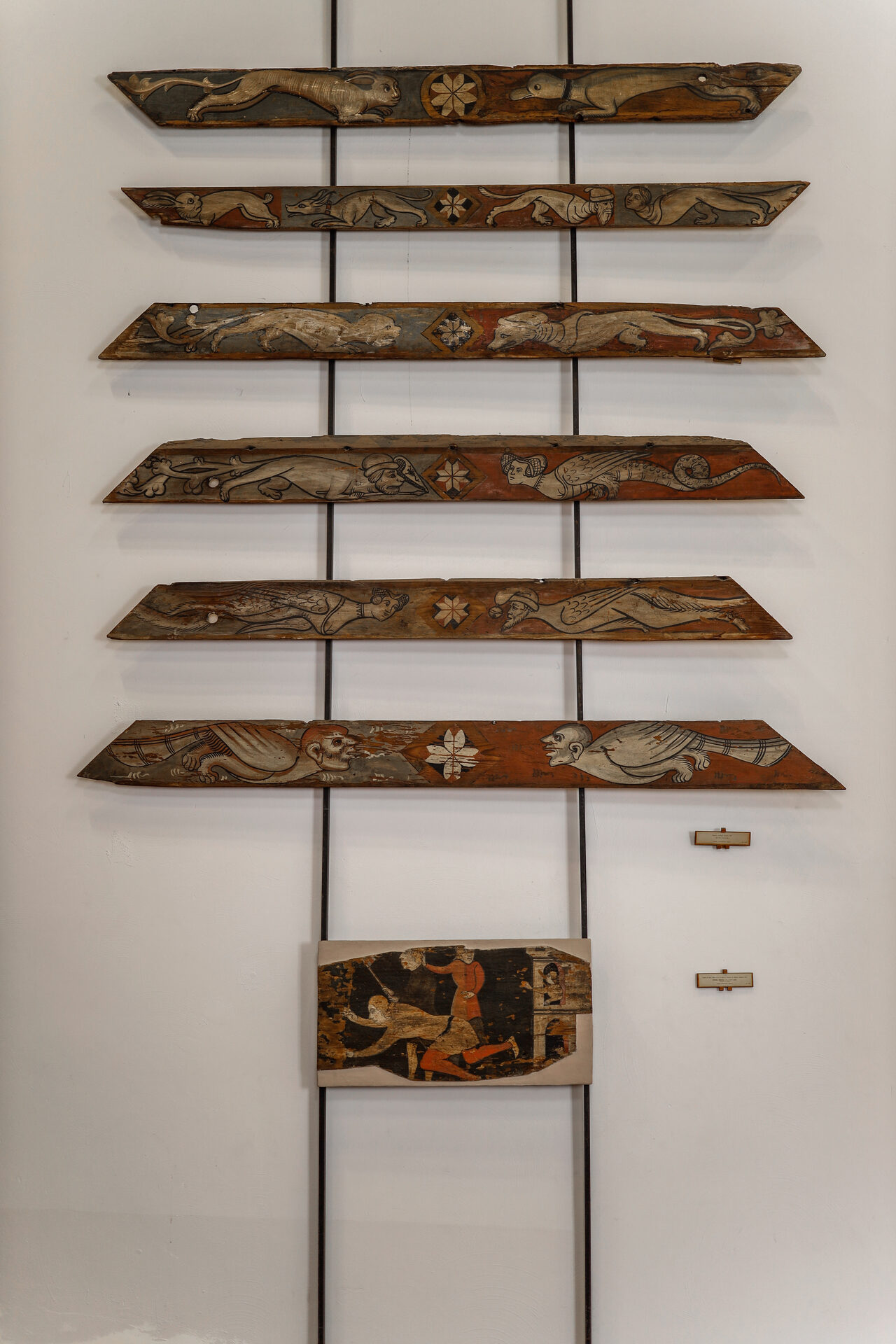 fragments of painted sicilian timber ceilings hung on the wall of palazzo abatellis