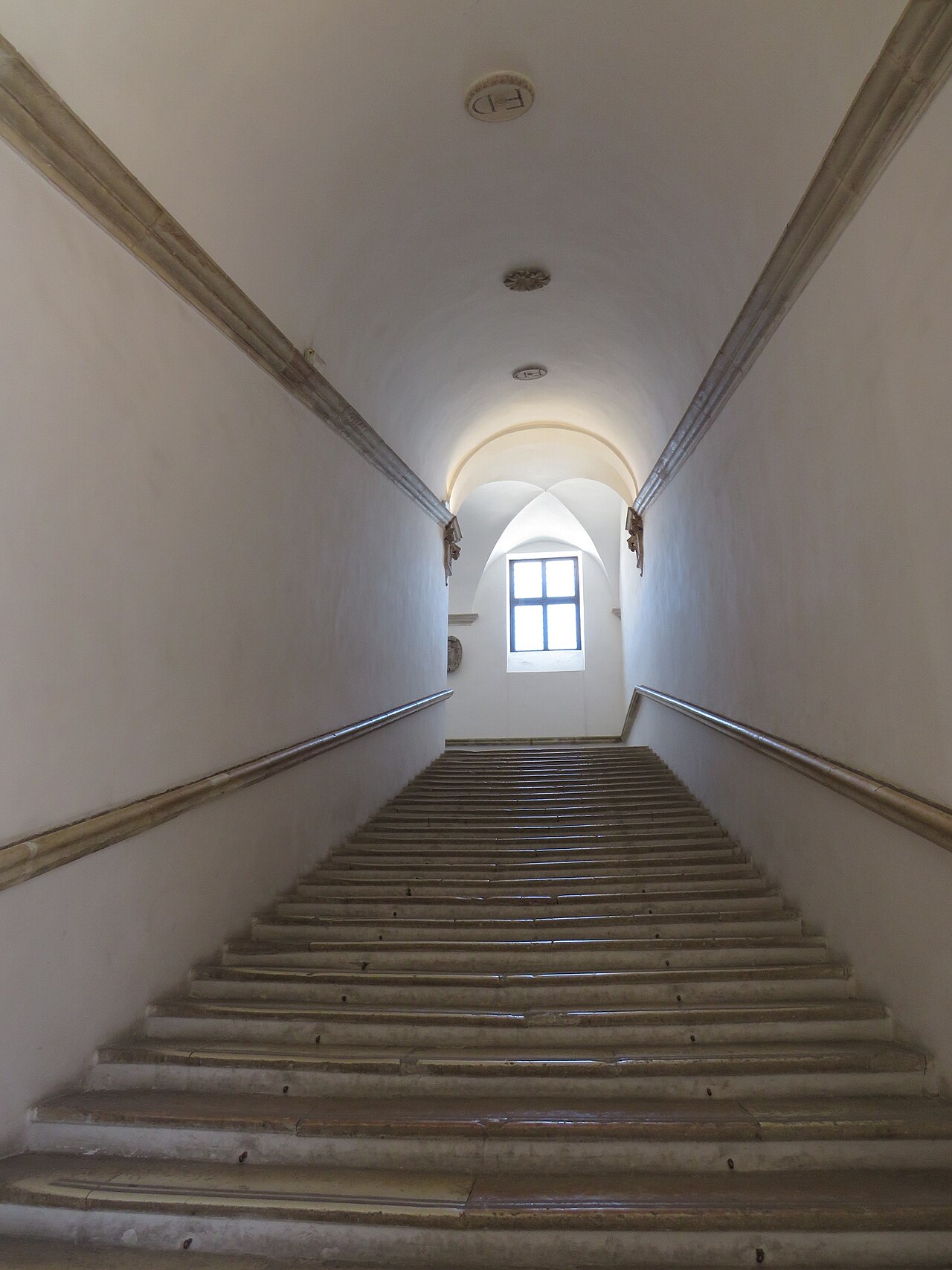 monumental staircase of the palace seen from below with a window at the far end