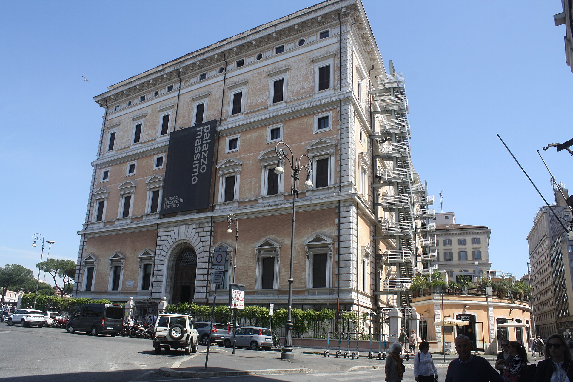 la facciata di palazzo massimo alle terme a roma, con lo stendardo verticale del museo nazionale romano sulla facciata accanto al portale ad arco