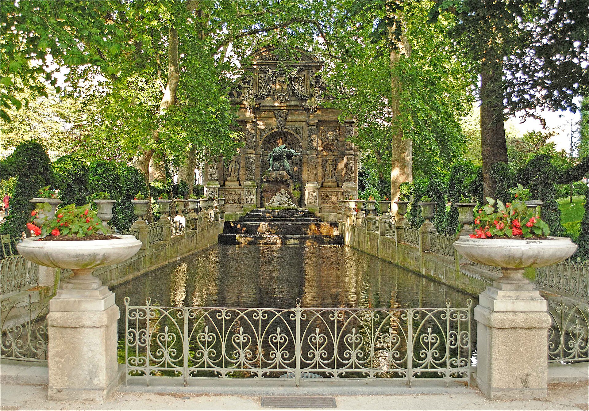 la fontana medici del giardino del lussemburgo a parigi, con la lunga vasca d’acqua fra due file di vasi di pietra e il gruppo di polifemo in bronzo nella nicchia in fondo