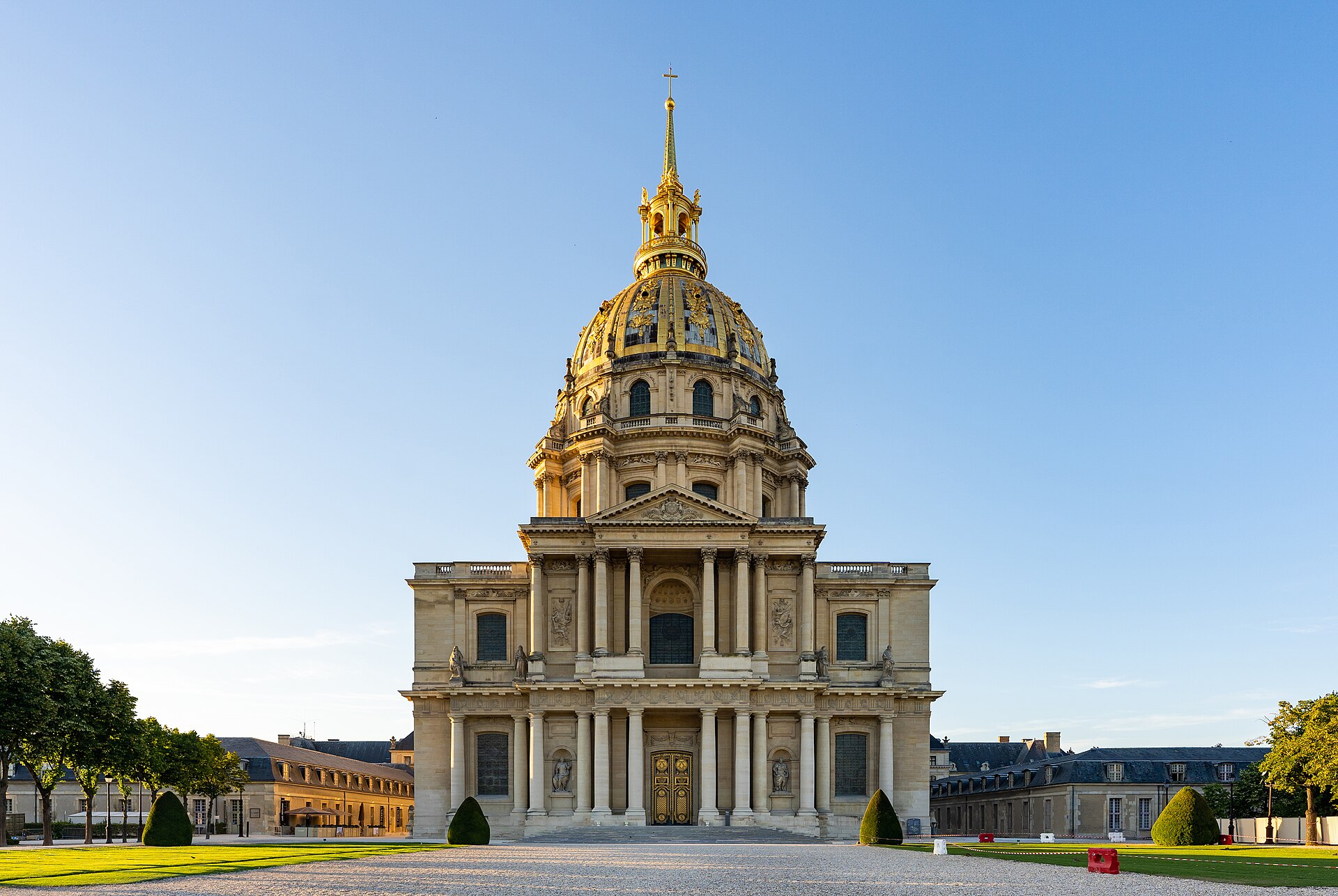 la facciata del dome des invalides a parigi con la cupola dorata, la guglia e il timpano, illuminata dal sole basso della sera