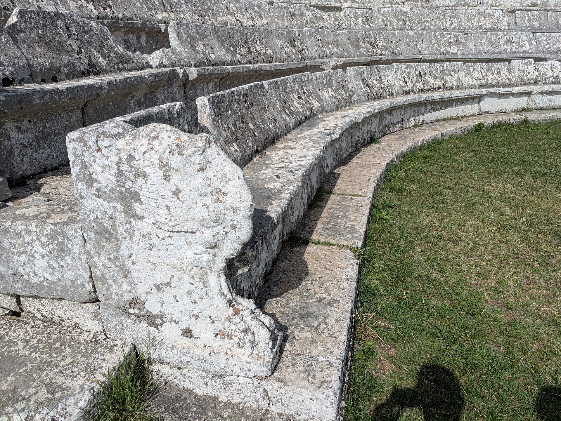 i sedili in pietra del teatro di pietrabbondante con lo schienale e il bracciolo scolpito a zampa di leone alata