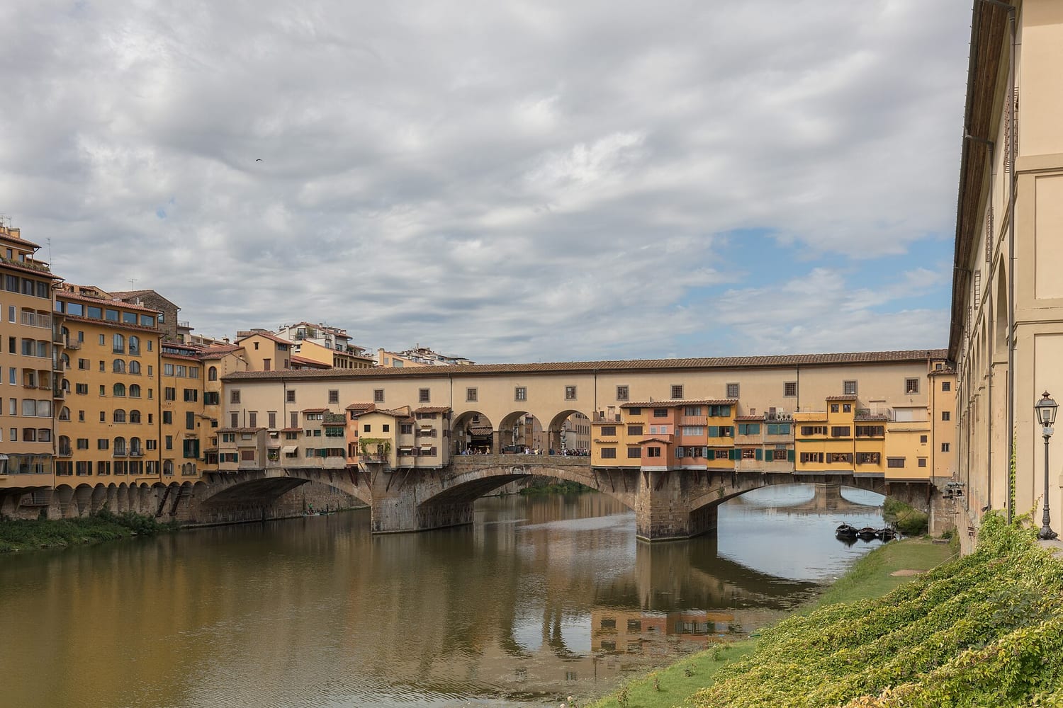 el ponte vecchio de florencia visto desde el arno con las tiendas volando sobre el río