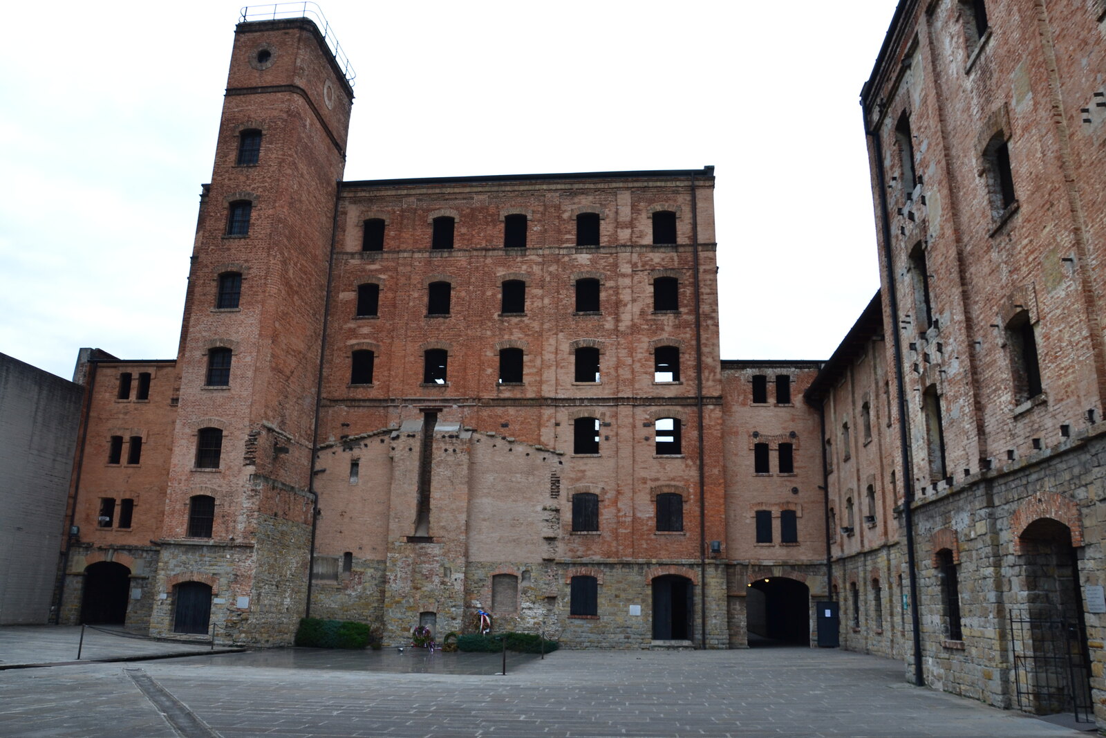 gli edifici in mattoni della risiera di san sabba visti dal cortile con la torre e le finestre murate