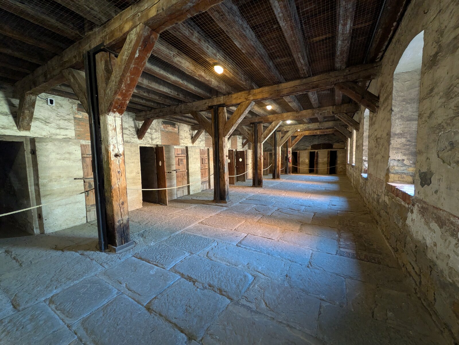 il corridoio dell edificio dei prigionieri della risiera di san sabba con le travi di legno e il pavimento in lastre di pietra