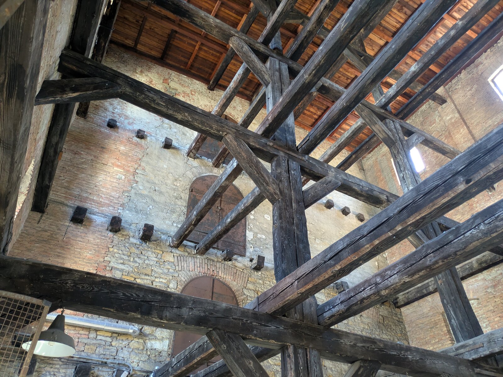 le travi di legno incrociate della sala delle croci della risiera di san sabba viste dal basso