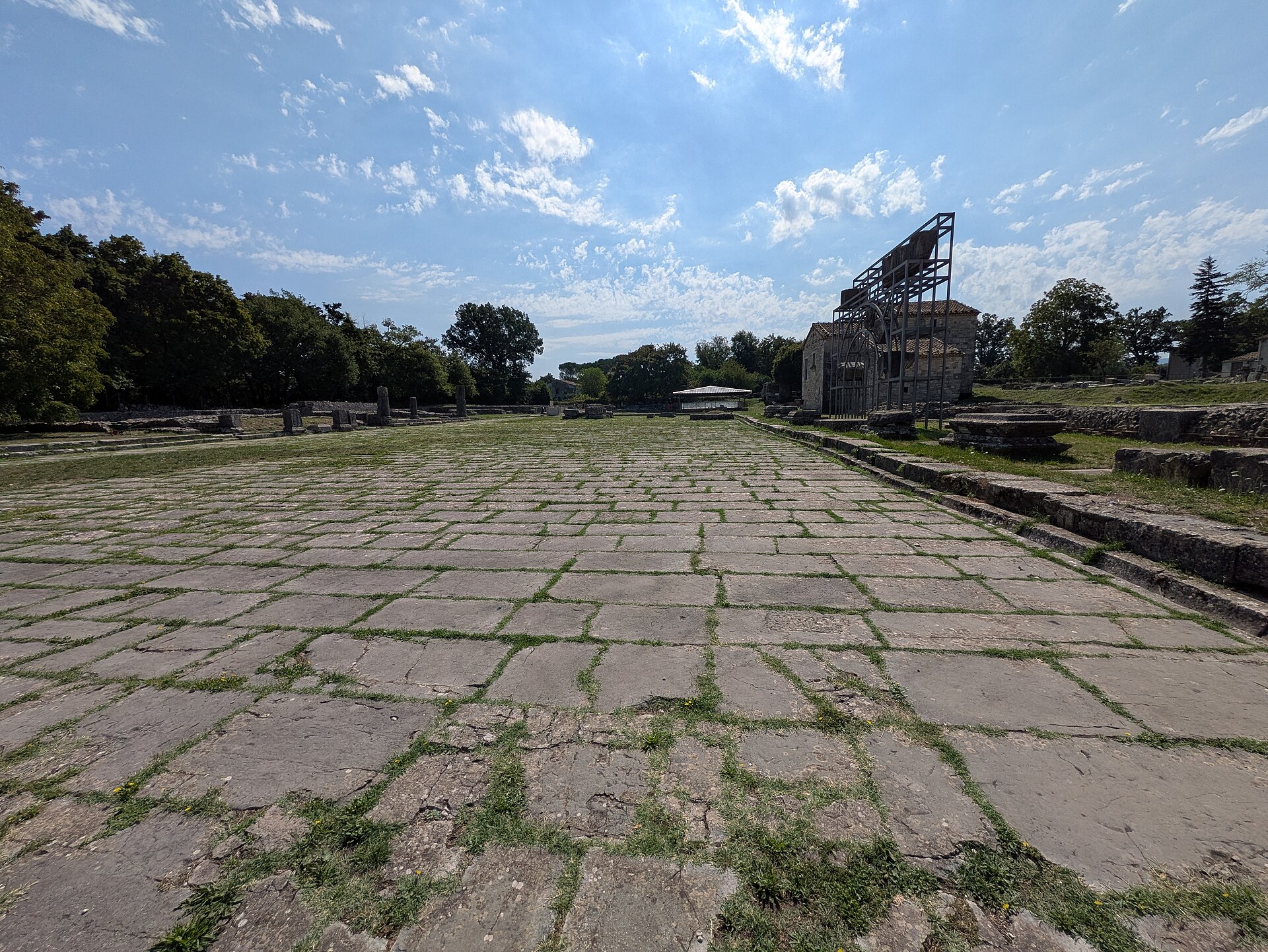 il foro lastricato di saepinum visto per il lungo, con la basilica e le case moderne in fondo