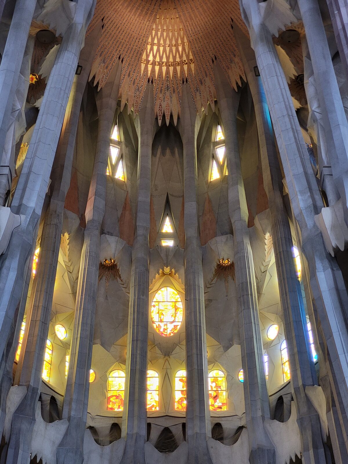 l’abside de la Sagrada Família avec ses colonnes et ses fenêtres dans une lumière chaude