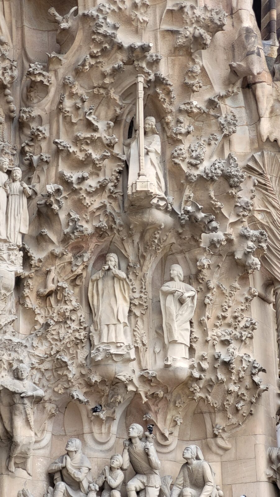détail de la façade de la Nativité de la Sagrada Família, avec les figures prises dans un enchevêtrement de feuilles et de fleurs