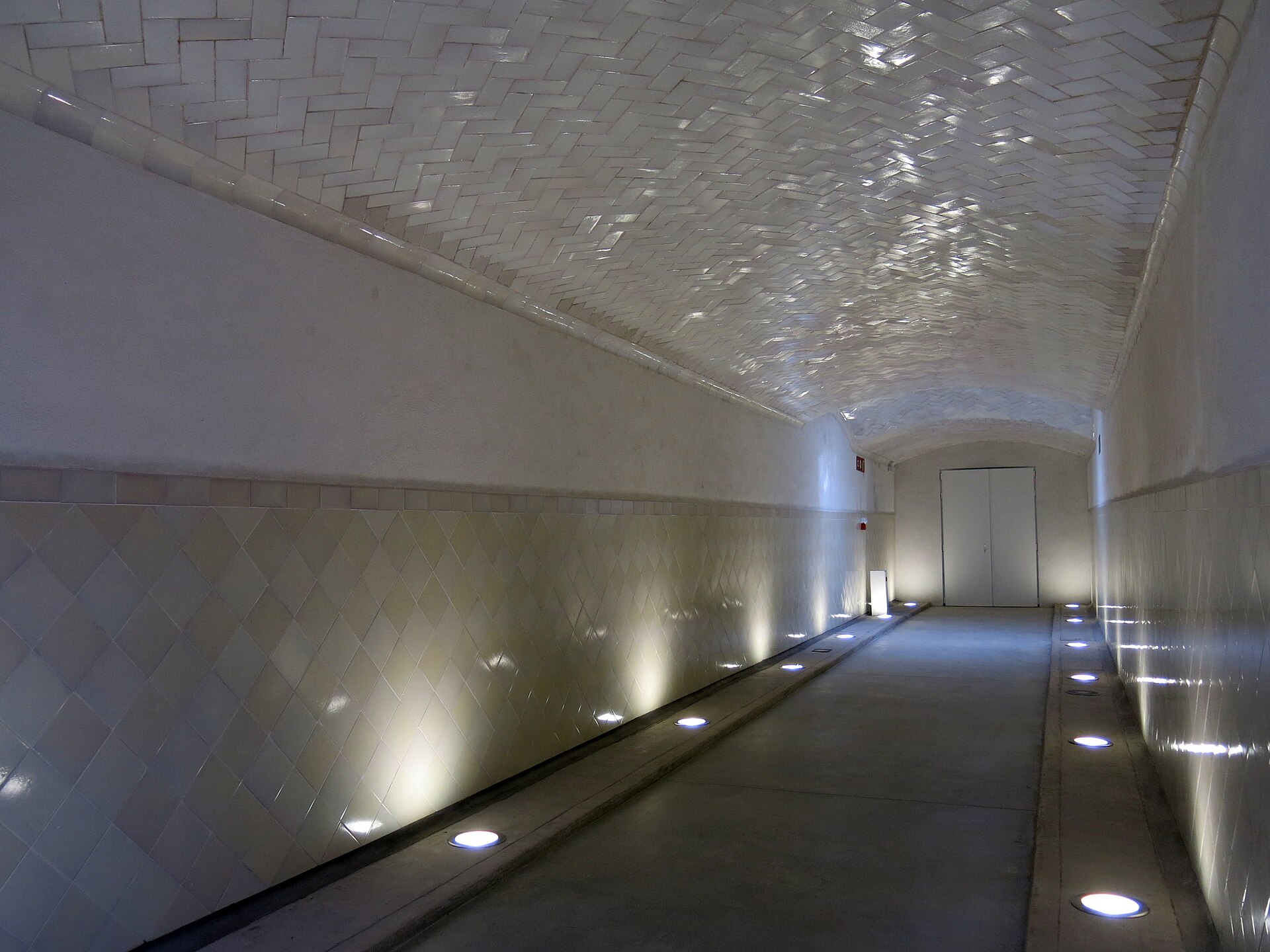 una galleria sotterranea di sant pau con le pareti di piastrelle bianche e le luci a pavimento