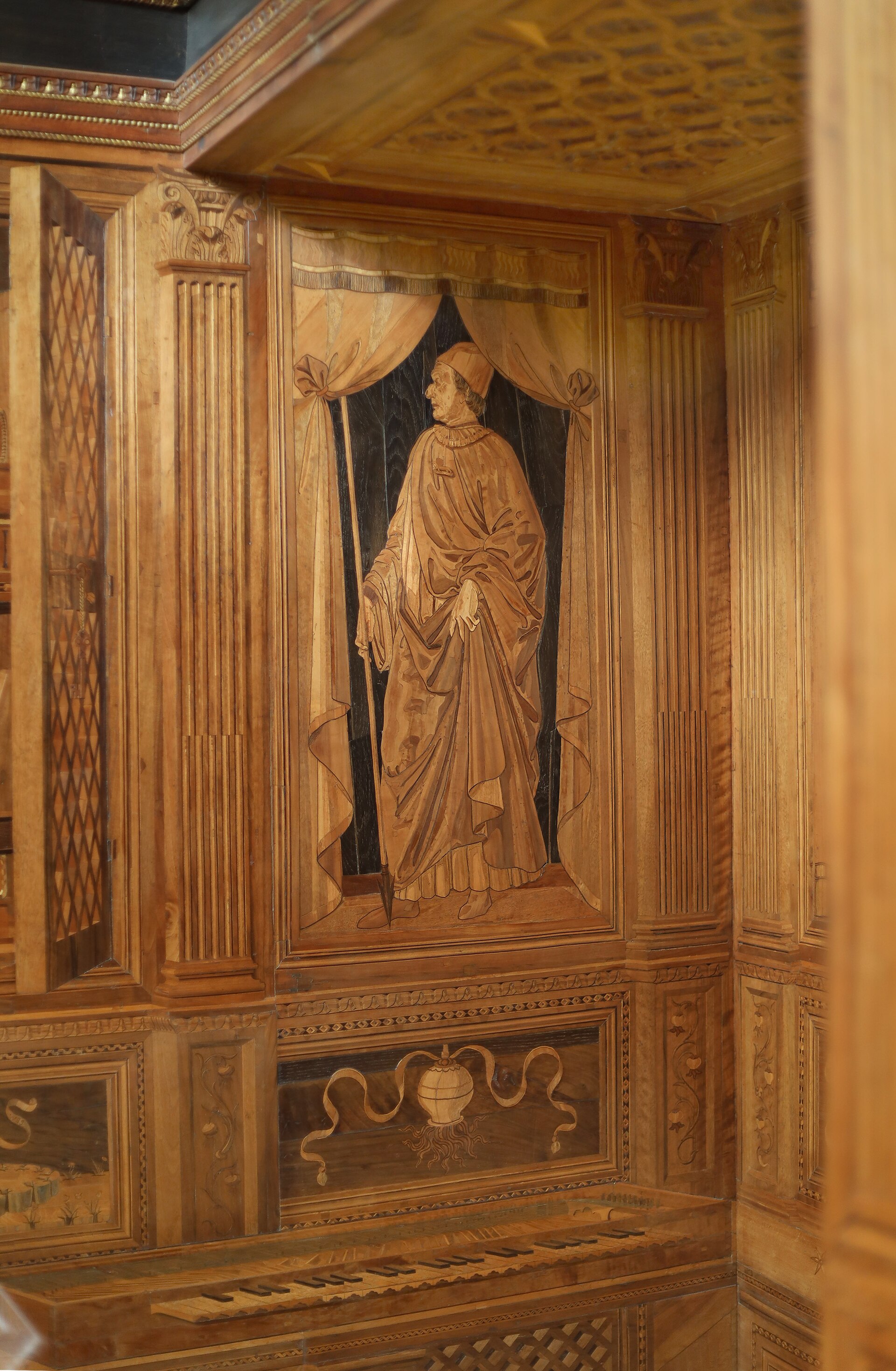 trompe-l’oeil inlay with a drawn-back curtain over an armed figure above the keyboard of a clavichord