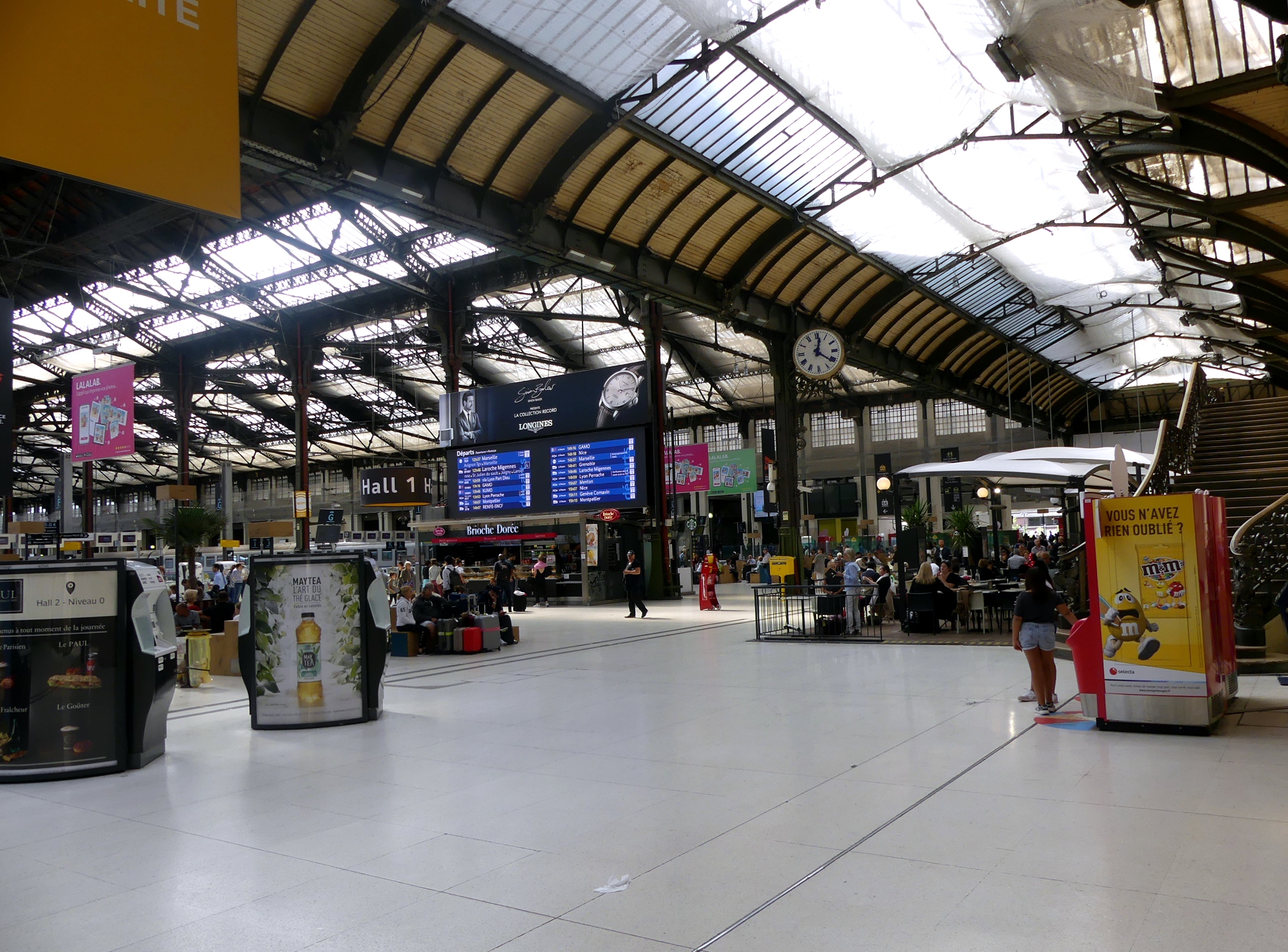 la grande sala della gare de lyon a parigi con il tabellone delle partenze e il soffitto a volta in ferro e vetro