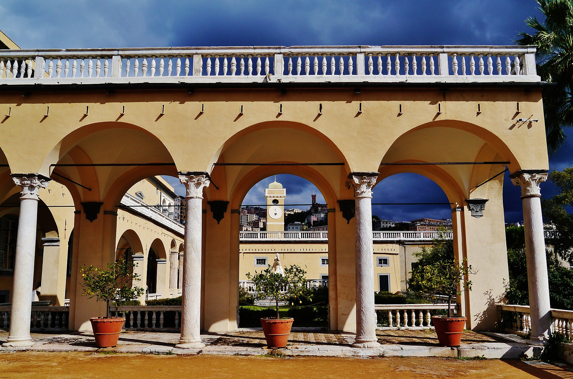 la logia de la villa del principe de genova con los citricos en macetas y un cielo oscuro de tormenta