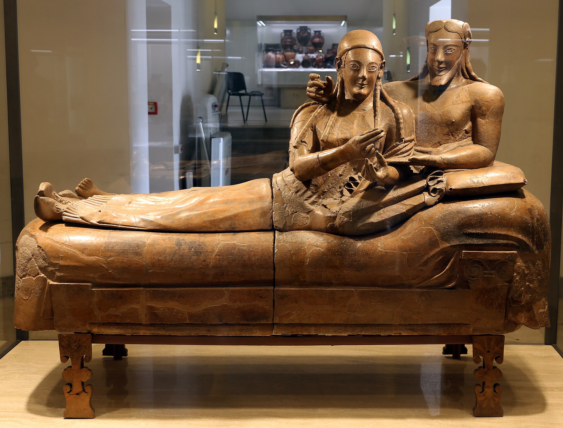 il sarcofago degli sposi in terracotta nella sua vetrina a villa giulia, con la coppia distesa sul letto da banchetto e l uomo che cinge le spalle della donna