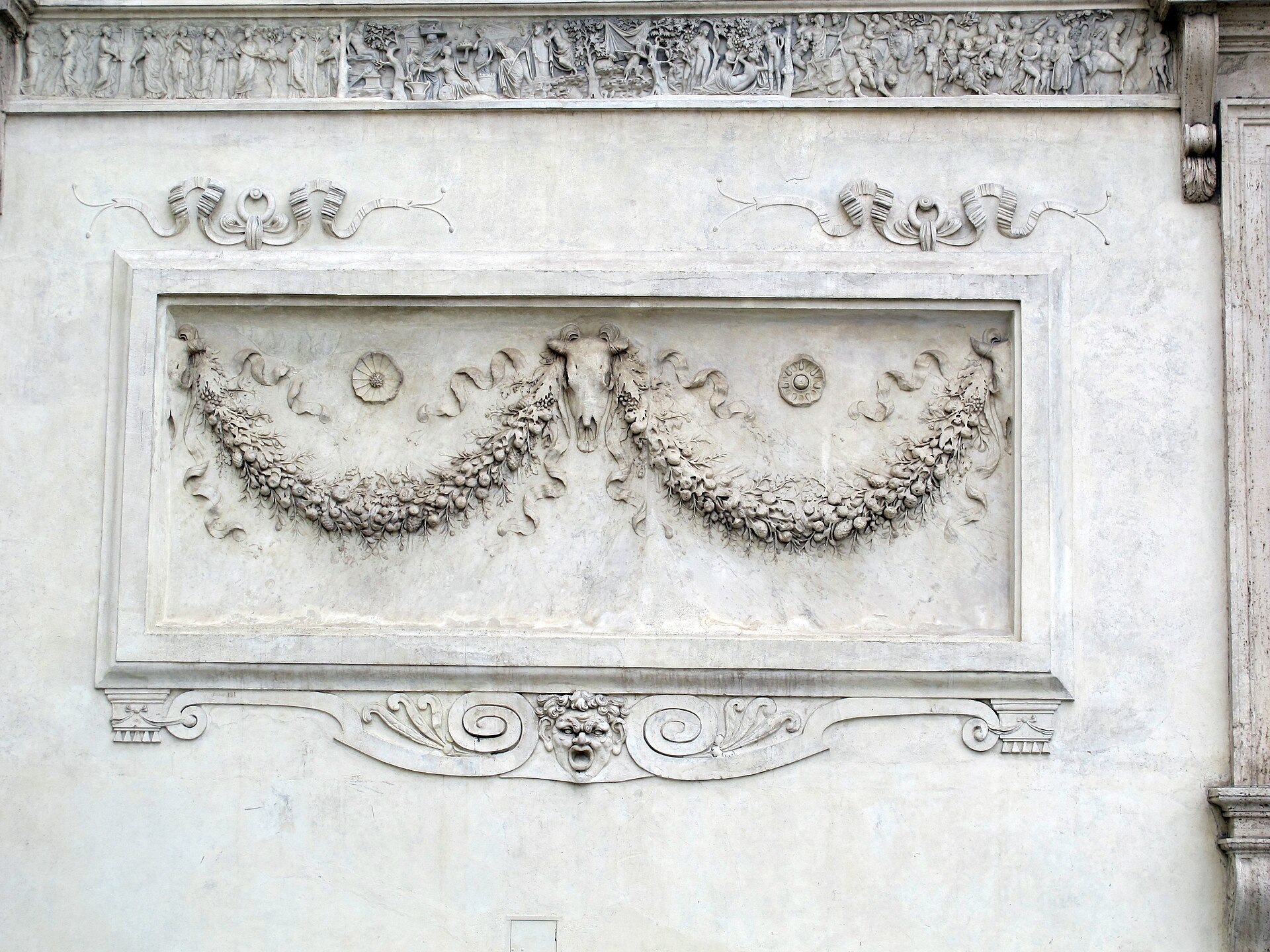 an ancient relief set into the garden facade of villa medici, with two garlands of leaves and fruit hanging from a central ox skull and two rosettes, inside a rectangular frame