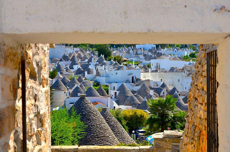 vista dei trulli di alberobello incorniciati da una porta